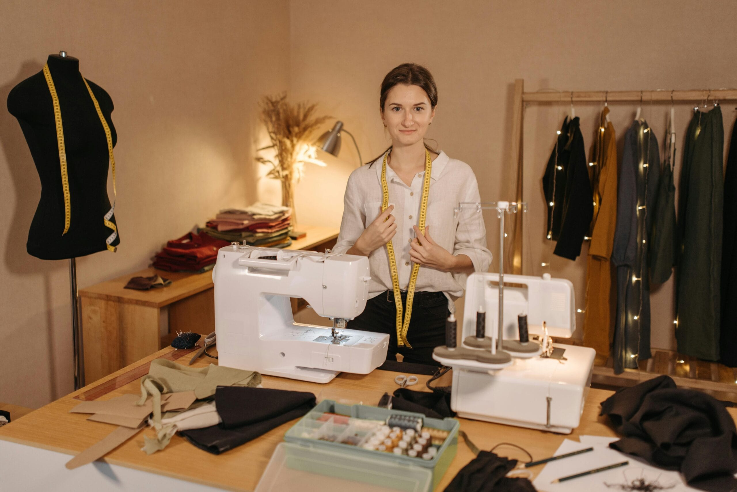 Vantagens 9 Adult woman with measuring tape in a sewing room with machines and fabrics.